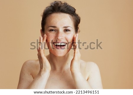smiling modern 40 years old woman with face scrub isolated on beige. Royalty-Free Stock Photo #2213496151