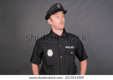 Portrait of Caucasian man wearing police uniform costume against gray studio background