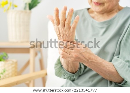 Asian senior woman having the joint pain at the living room