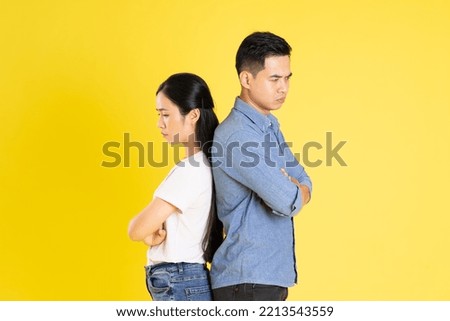 image of asian couple posing on yellow background Royalty-Free Stock Photo #2213543559