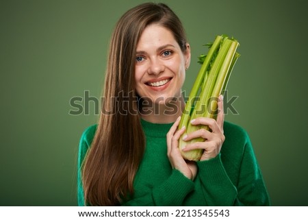 Woman holding celery for diet and healthy eating. Advertising isolated portrait on green.