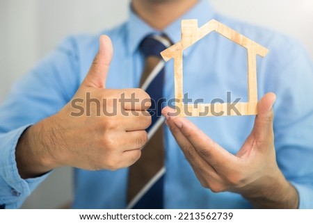 Businessman, agent or broker at front. To hold model of home, house or residential building in hand and offer to sale, rent buy, purchase and investment. Concept for business, real estate, property.
 Royalty-Free Stock Photo #2213562739