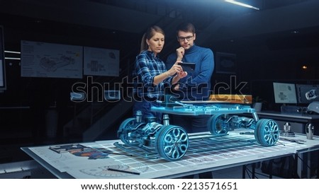 Automotive Engineers Working on 3D Electric Car Design Through Smartphone AR Software, Using Gestures in Augmented Reality. Designing Graphical Parts, Picks Body and Color for the Chassis, Engine