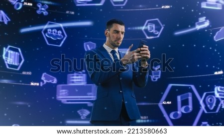Virtual Reality Concept: Successful Businessman Uses Smartphone in 3D World Surrounded by e-Business, e-Commerce, Stock Market, Infographics, Finance, Analysis, Charts, Graphs Icons.