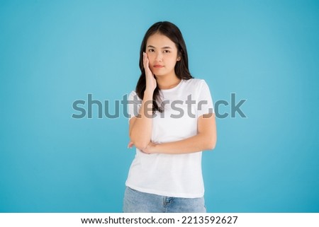 Beautiful Asian woman standing doing various poses on a blue background happy smile feel relaxed and fun.