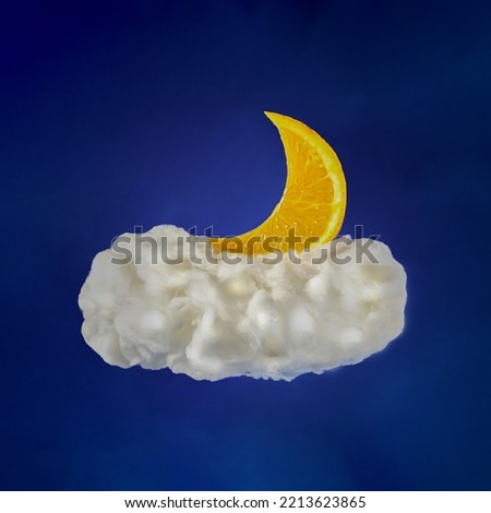 slice of orange like moon liyng down on bright white cloud in the sky on dark blue background. minimal creative composition.