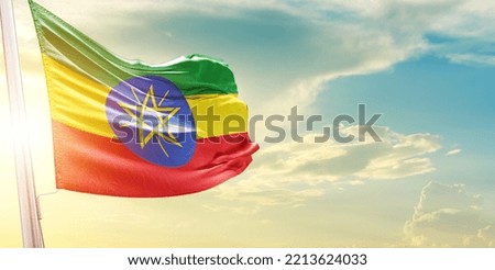 Waving Flag of Ethiopia in Blue Sky. The symbol of the state on wavy cotton fabric.