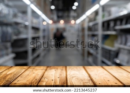 Empty wooden table with blurred background of supermarket or grocery store.