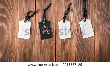 White and black sale tags hanging on wooden background