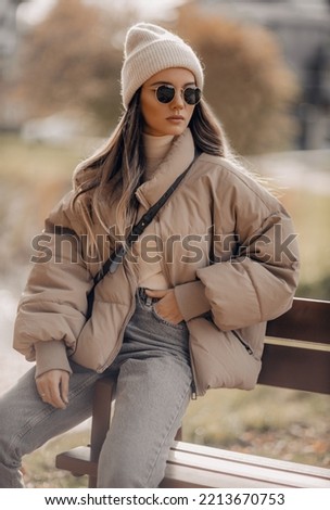 Stylish young woman posing in outdoor. Beautiful autumn outfit. Royalty-Free Stock Photo #2213670753