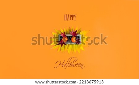 Creative Halloween design made of  pumpkins, acorns, red an yellow autumn leaves in golden box against bright orange background. Minimal concept. Copy space. Happy Halloween.