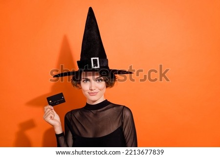 Photo of charming witch lady arm hold demonstrate debit plastic card isolated on orange color background