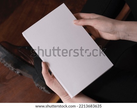 Woman holding blank white book mockup template