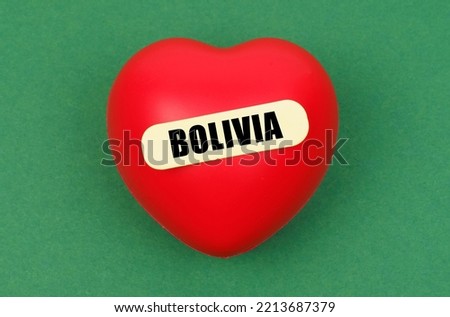 Love to motherland. On a green surface lies a red heart with the inscription - Bolivia