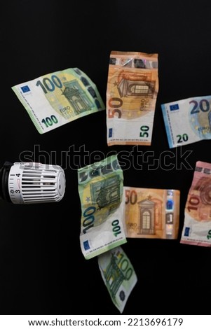 expensive heating costs. Thermostat with several falling euro banknotes