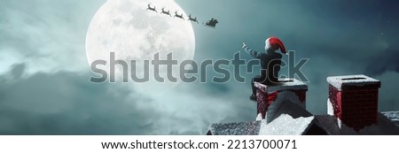 child surprised to see Santa Claus above the fireplace on beautiful Christmas night under moonlight