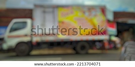 Defocused abstract background of a bok truck parked in front of a traditional market.