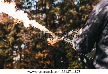 A flame thrower being fired Royalty-Free Stock Photo #2213711875