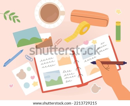 One hand is decorating a diary with pictures and stickers and writing. Stationery is scattered on the table. flat vector illustration.