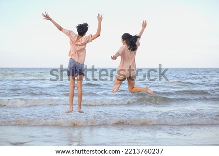 A happy and cheerful Friends or Couple jumping on the beach. Concept of relationship, friendship, jouful, excitement, teamwork. Family vacation. Quality time
