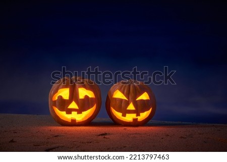 Halloween pumpkins jack p lantern on the sea beach at night in the bright moonlight