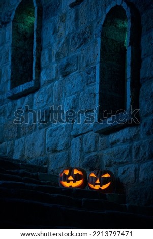 Halloween pumpkins jack p lantern in the yard of an old castle at night in the bright moonlight