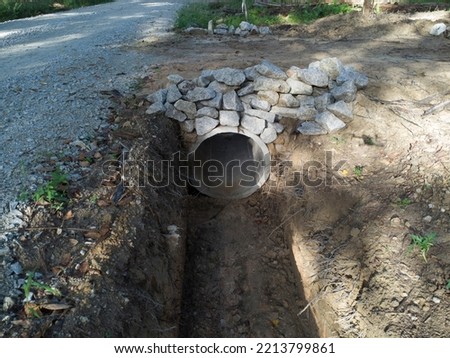 aerial scene of the concrete cylindrical drain at the countryside road Royalty-Free Stock Photo #2213799861
