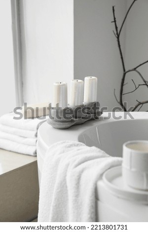 Holder with candles on modern bathtub Royalty-Free Stock Photo #2213801731
