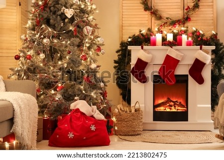 Interior of living room with Santa bag, fireplace and Christmas tree