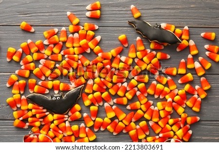 Halloween candy corns and cookies on dark wooden background