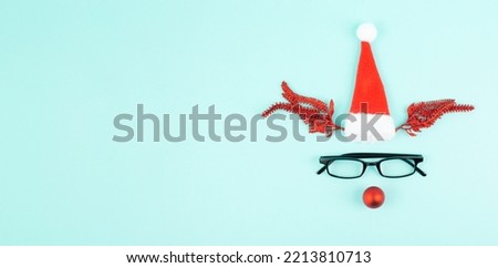 Reindeer with a red bauble nose, antlers, a santa claus hat and eyeglasses, merry christmas greeting card 