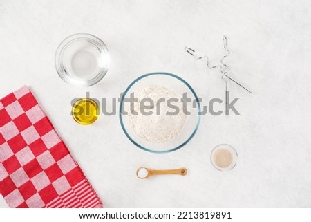 Pizza dough. Food styling. Preparing recipe. Flat view of ingredients, flour, oil, yeast, water, salt. An easy to make homemade pizza dough recipe. Creativity and minimalism. Food photography.
