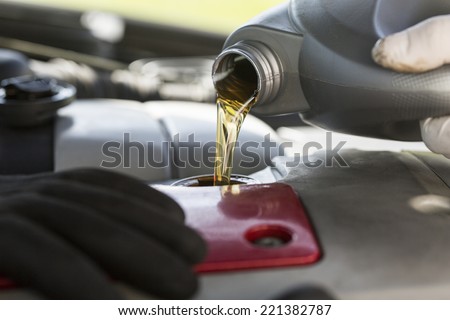 Fresh oil being poured into a car during a service Royalty-Free Stock Photo #221382787