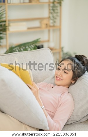 Asian woman lying on vacation reading a book