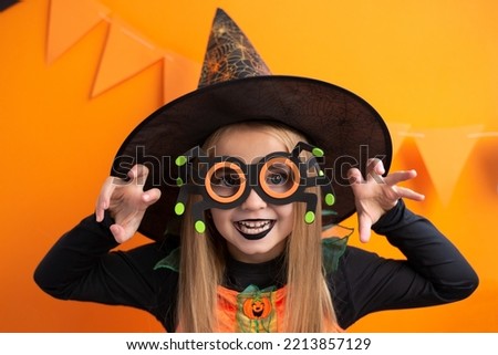 Happy Halloween! Cute little girl in Halloween costume,witch hat and spider glasses