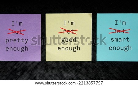 Three paper notes with handwritten text I AM NOT GOOD ENOUGH, NOT SMART ENOUGH, NOT PRETTY ENOUGH - crossed off NOT to overcome self criticism, boost self esteem, validation and acceptance Royalty-Free Stock Photo #2213857757