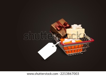 basket with gifts and white tag on black background