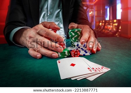 Gambling concept. Close up of Poker Player male hand Winning Royal Flush at casino, gambling club. Сasino chips or Casino tokens,  dice, poker cards, gambling man lucky guy, games of chance. Royalty-Free Stock Photo #2213887771