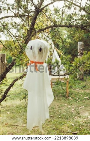 Halloween ghosts decoration hanging on tree branches. Easy autumn DIY outdoor yard decor and holiday ideas for party. Selective focus, copy space