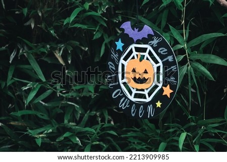 Cute Halloween decorations hanging on a tree in the forest to celebrate Halloween, festive holiday design concept.