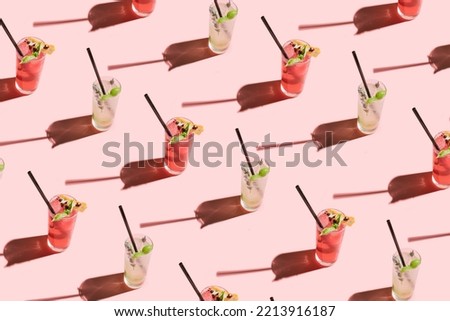 Creative pattern made of cocktails
with straw on pastel pink background with sunny day
shadow. Minimal summer party concept. Celebration and event visual.