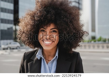 Happy business african woman working outdoor with office buildings on background - Focus on face