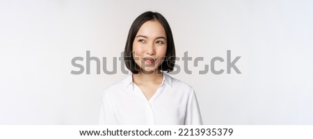 Image of smiling asian woman planning, thinking of smth, daydreaming, standing over white background with smug face Royalty-Free Stock Photo #2213935379
