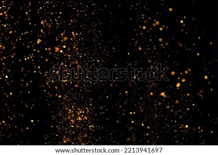 Shiny glitter particles overlay abstract bokeh texture isolated on black background 