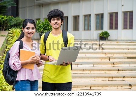 closeup shot of Happy smiling students with backpack holding laptop and smilling at camea at college campus - concept of technology, learning and skill development. Royalty-Free Stock Photo #2213941739