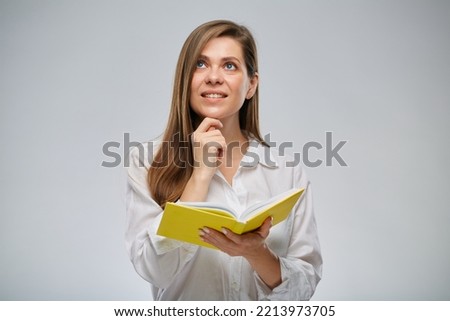 Thinking student woman holding open yellow book and looking up, isolated female portrait.