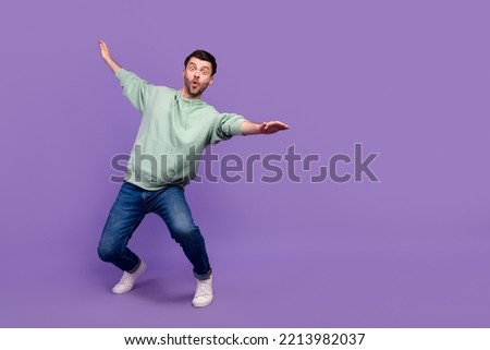 Full body photo of attractive young guy surfing falling keep balance wear trendy gray garment isolated on violet color background