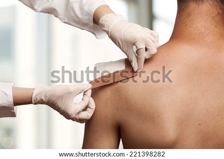 Medical assistant changes the dressing of a wound at the emergency room Royalty-Free Stock Photo #221398282
