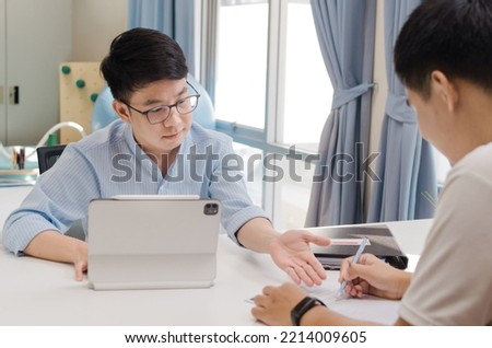 A men explains something with another on his working table. soft focus picture.