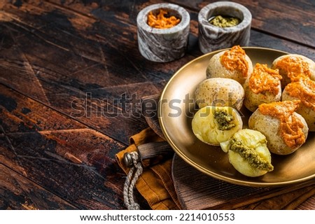 Canary Islands dish Papas Arrugadas wrinkly salty potatoes with and Mojo picon red spicy sauce. Wooden background. Top view. Copy space. Royalty-Free Stock Photo #2214010553